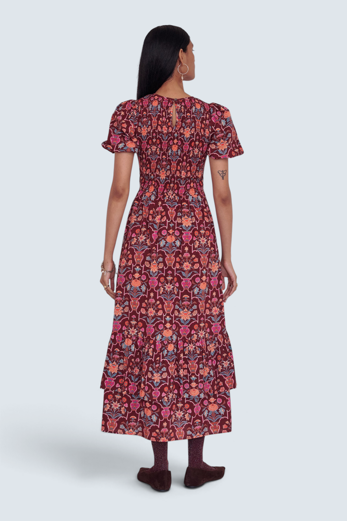 Back view of a model wearing a Banjanan Quant dress in chestnut floral vase print with smocked bodice and tiered skirt