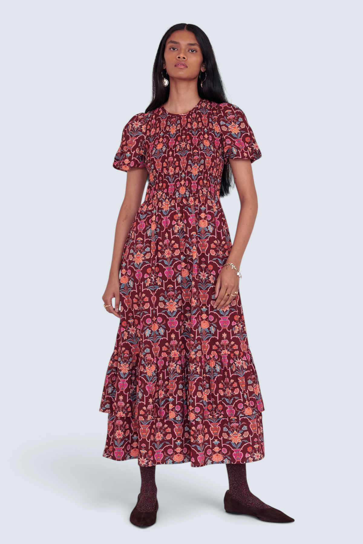 Banjanan Quant dress in chestnut floral vase print with smocked bodice, puffed sleeves, and tiered midi skirt.
