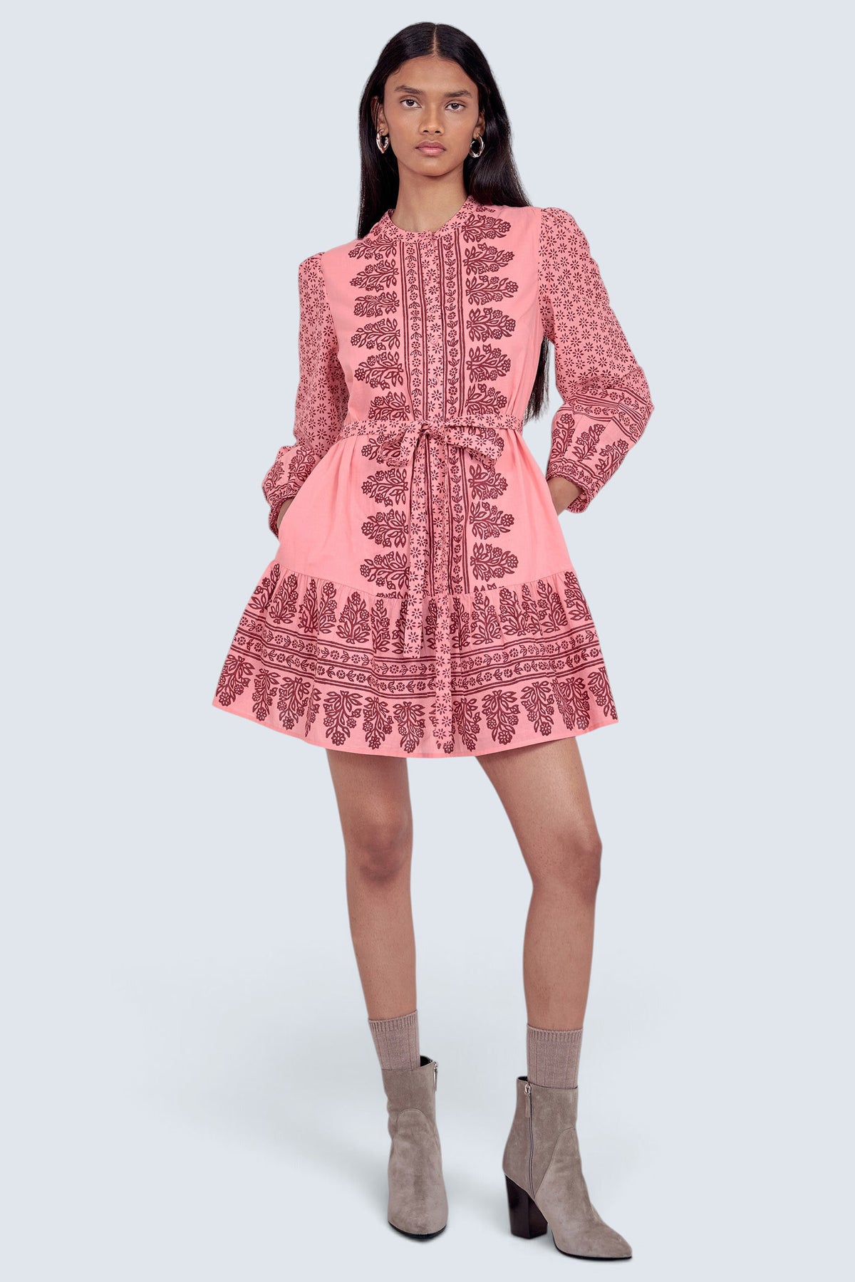 Front view of model standing wearing the Roma dress in Eugenie print, featuring a mini length, wrist-length sleeves, a detachable belt, and side-seam pockets.
