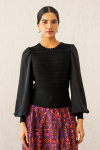 Front view of woman wearing the Rosie knit, featuring hand-crocheted details and viscose georgette sleeves, blending structure with textural complexity.