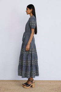 Side view of model standing wearing a full length Saylor Dress in Victorian Gingham Midnight print.