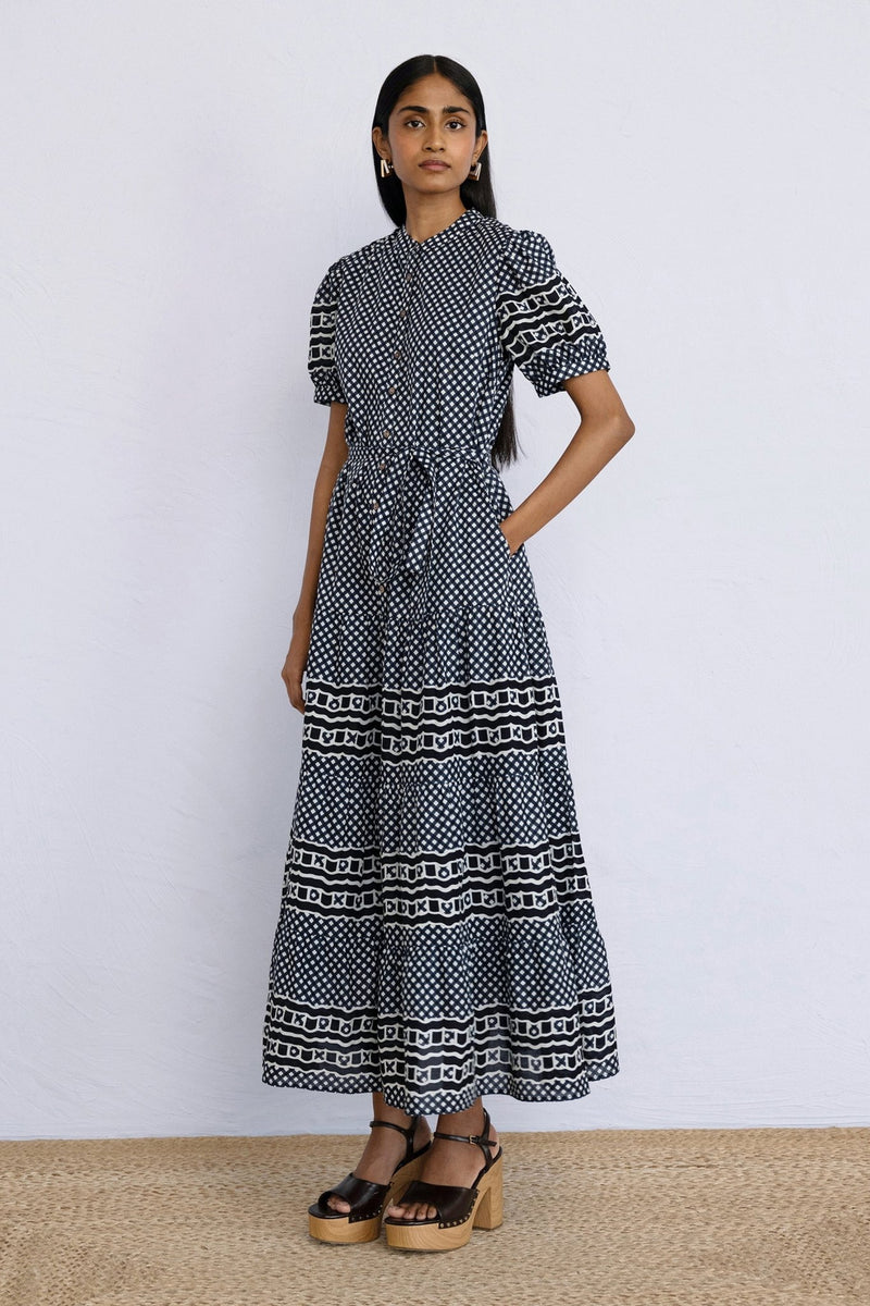 Front side view of model standing wearing a full length Saylor Dress in Victorian Gingham Midnight print with a hand in pocket.