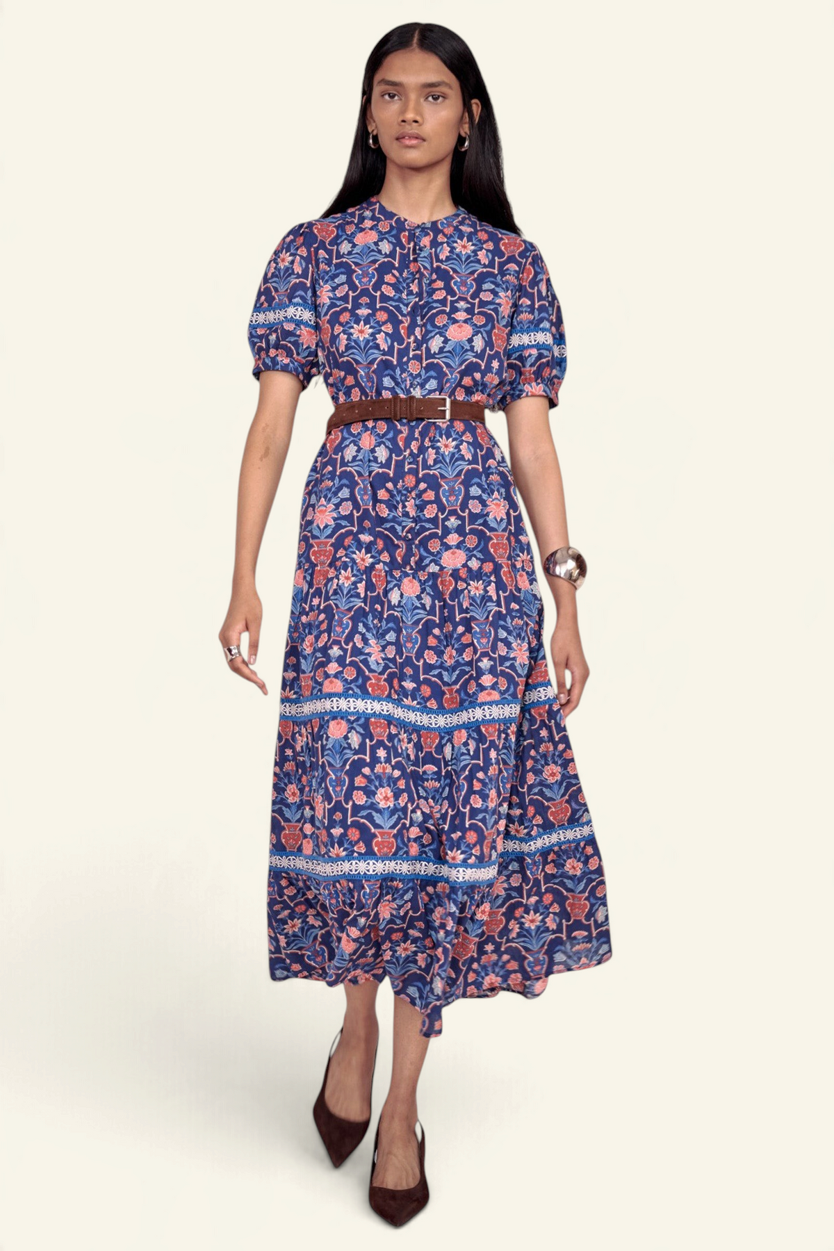 Banjanan Saylor full-length shirtdress in blue floral vase print with lace trim, tiered skirt, and brown waist belt.