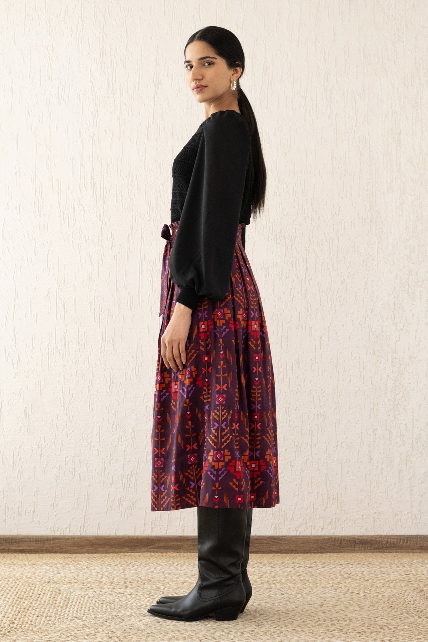 Side view of a woman wearing the Tobias skirt with a paper bag waist, self-tie belt, and pockets in Emilie Deco Cinnamon print, inspired by Austrian Art Nouveau.