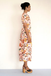 Side view of woman standing wearing Valeria Dress Bali Floral Lotus.