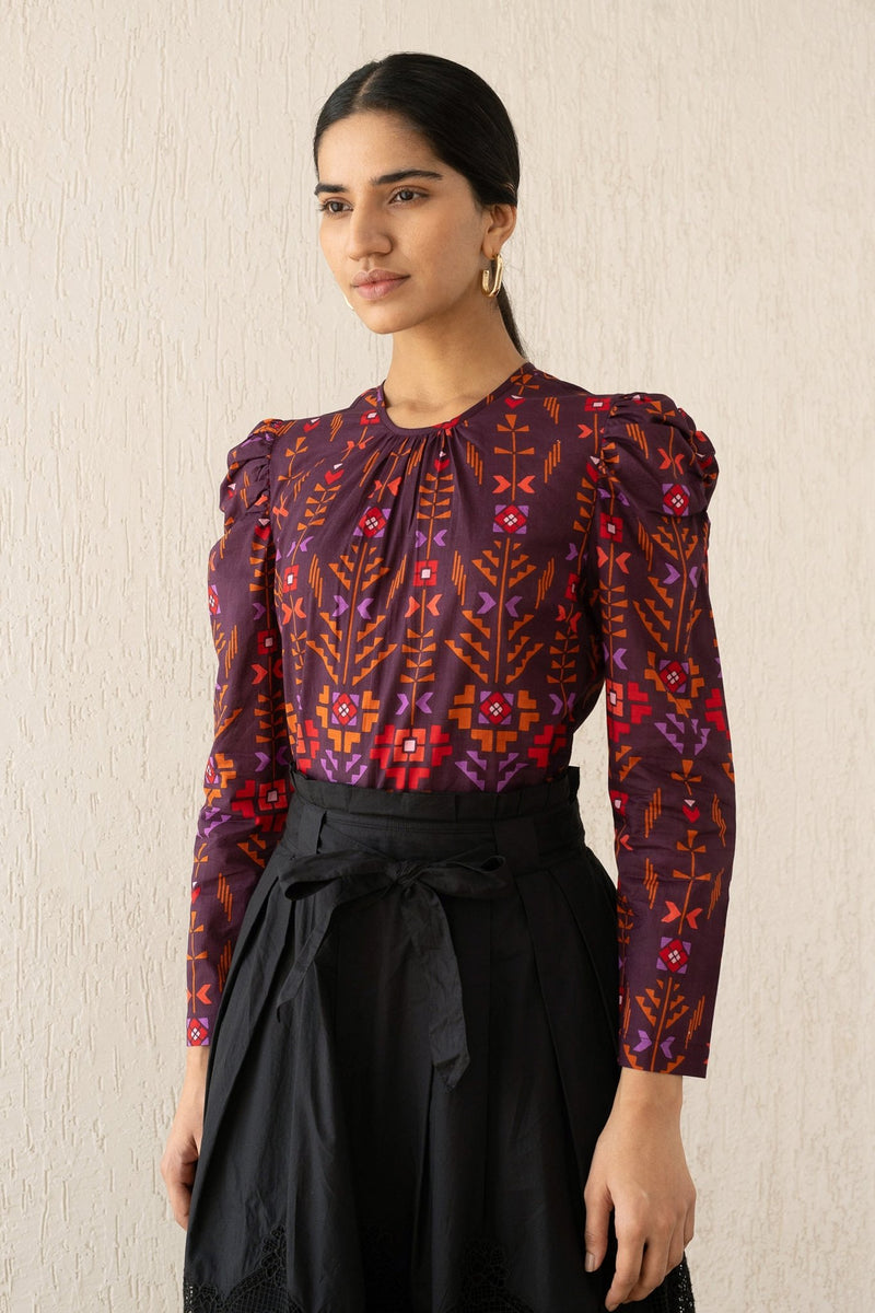 Side view of a woman wearing the Vincent top with soft gathers at the neck and shoulder, featuring a zipper at the back in Emilie Deco Cinnamon print, inspired by Art Nouveau.